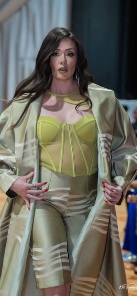 Sage coat with chartreuse corset top on the runway