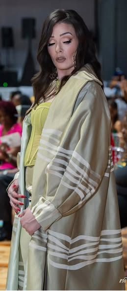 Sage coat with white stripe sleeves on the runway