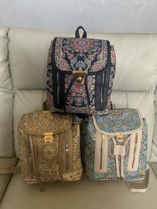Three tapestry backpack purses in teal, gold and black